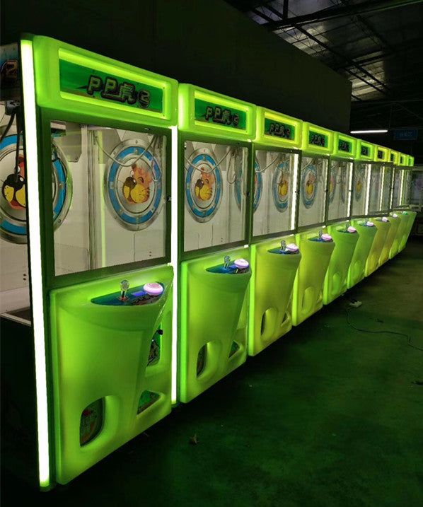 Row of PP Tiger branded claw crane machines with green LED lighting in a factory showroom — commercial claw machine wholesale supply from Hiclawcrane