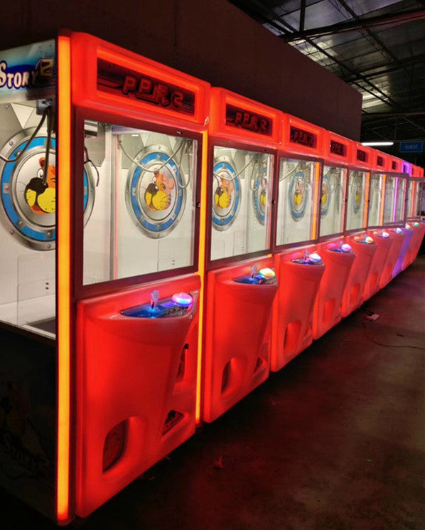 Row of PPR2 branded commercial claw crane machines with red LED lighting in an arcade venue — factory-direct wholesale claw machine supplier Hiclawcrane